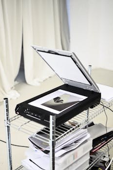 Opened contemporary scanner placed on metal shelf in modern office with light curtain